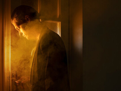 A side view of a man surrounded by smoke, symbolizing solitude and individualism, captured in a poignant image