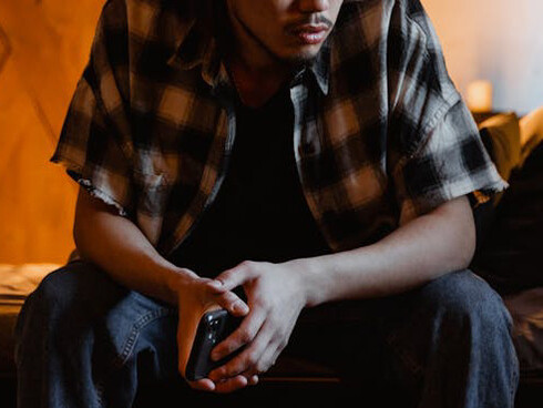 Engulfed by the silent room and the flickering screen, he reflects on how social media's ideals clash with his own sense of worth