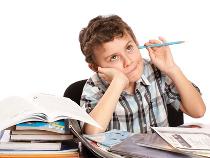 Niño distraído frente a los libros de texto