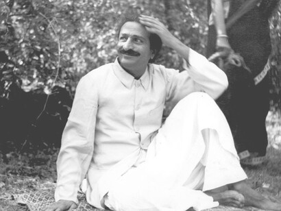Meher Baba in Trimbak, sitting on a garden