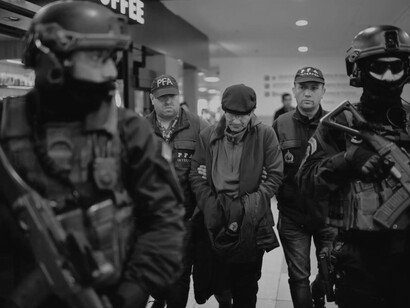 Mario Sandoval, previously an Argentinian police officer accused of crimes against humanity during the "dirty war," is accompanied by law enforcement at Buenos Aires’ Ministro Pistarini International Airport on December 16, 2019, after his return from France