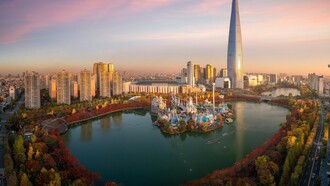 During autumn in Seoul, South Korea, the vibrant colors of the leaves surround the peaceful lake in the park