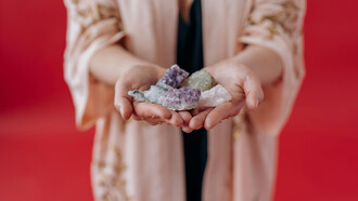 A woman holds healing crystals in her hands, channeling calm and positive energy