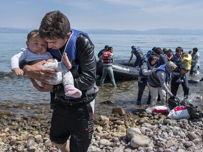 Voluntarios atienden a refugiados sirios recién llegados a costas europeas