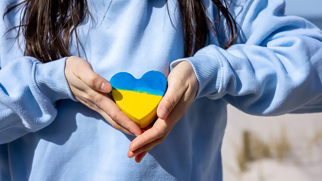 Closeup heart in the color of the flag of ukraine in female hands