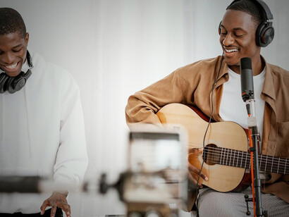 Captivating world of amapiano music with a compelling front view image of male musicians at home, skillfully playing guitar and piano, embodying the soulful rhythms of amapiano melodies