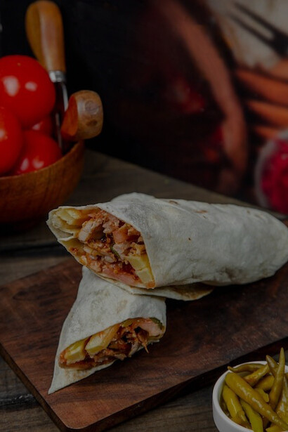 Side view of shawarma with fried potatoes and ayran, served with mayonnaise on a wooden board—Turkish doner kebab
