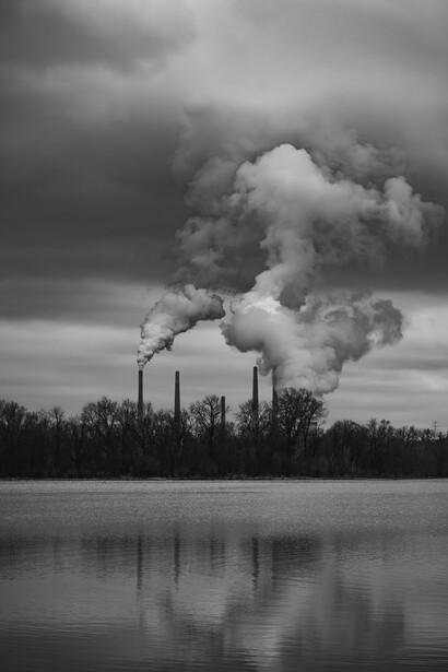Black and white image of smoke coming out from a power plant