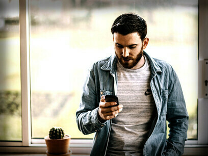 A young man absorbed in social media on his phone