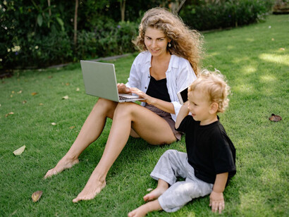 Embracing a balanced life means blending work with family time seamlessly, as shown by this mom multitasking in her garden while her child plays nearby