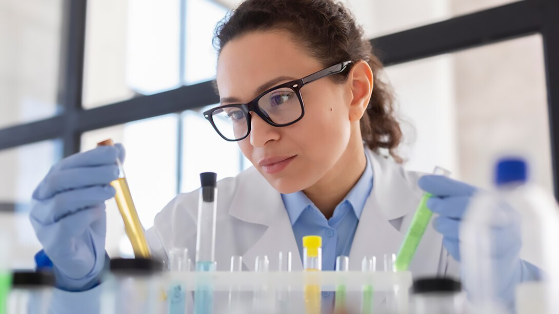 A scientist holding a test tube illustrates the crucial role of science communication in research, with scientific advisors ensuring that findings are effectively shared with and understood by the public
