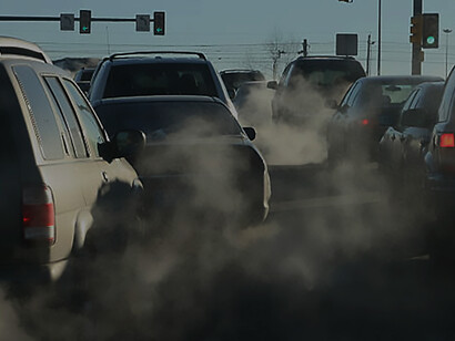 Amidst the city's air pollution crisis, a diesel vehicle's exhaust pipe releases pollutants on a bustling highway. This striking image underscores the critical need for environmental awareness and urgent adoption of sustainable transportation solutions for improved urban air quality