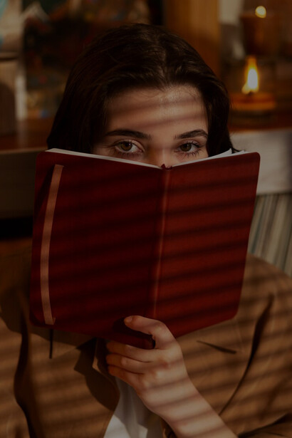 A woman writing in her journal at home delves into the intersection of creative freedom, ethical storytelling, and the publishing industry's influence on cultural sensitivity and writing morality