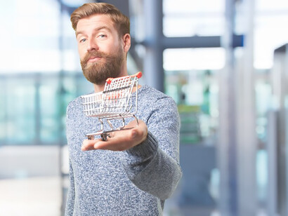 A gentleman grasps a miniature shopping cart, emblematic of a shopping adventure