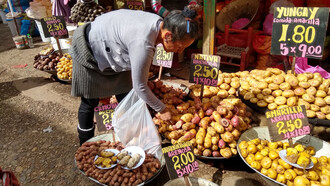 Mujer comprando papas en el Mercado Modelo de Huancayo, Perú