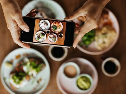 Female hands expertly capture meal photos with a smartphone, enhancing online visibility