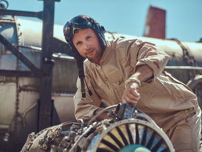 A man in overalls fixing an airplane turbine