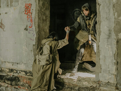 Two people move throught a ruined building