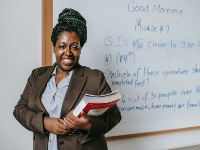 Professora segura livros em sala de aula
