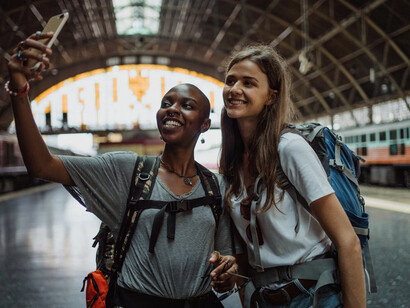 Two eco-explorers ready to embark on a conscious journey at the train station, embracing sustainable travel with every step