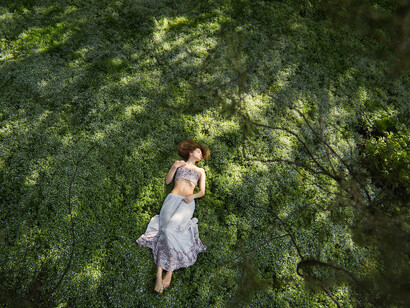 A young woman, resting on a forest clearing