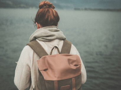 A travelling woman at a lake shore