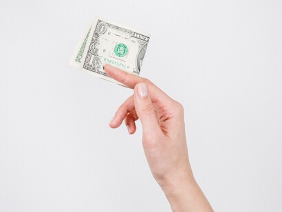 A dollar bill being raised