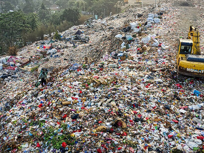 The presence of a substantial garbage dump, accompanied by construction equipment upon it, underscores the critical significance of implementing effective waste management strategies to address environmental challenges and promote sustainable practices