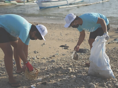 Two Indonesian men are dedicatedly cleaning the beach as part of their commitment to an ocean cleanup organization