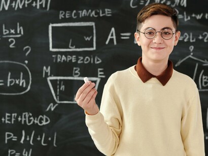 A middle school student holding a piece of chalk after being called to the blackboard
