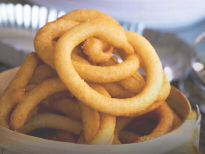 Sel roti is a traditional Nepalese rice-based doughnut, deep-fried to a crispy exterior and soft, chewy interior, commonly enjoyed during festivals and special occasions