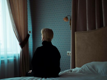 A woman sitting on the edge of her bed finding it difficult to get up due to depression