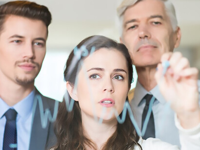 In-depth business analysis session led by a serious businesswoman, demonstrating graph insights to her attentive colleagues, fostering a collaborative work environment