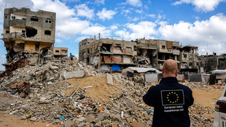 An aid worker surveys the devastation in Gaza, where humanitarian assistance remains a vital lifeline for communities struggling amid widespread destruction and displacement
