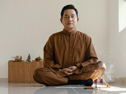 A man calmly meditating, wearing traditional clothing