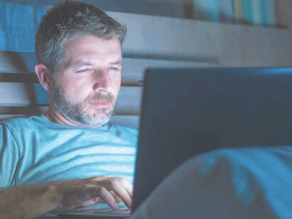 A man engrossed in his computer, battling addiction