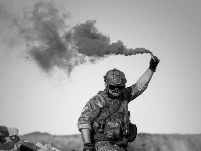 A soldier lighting up a flare in the desert