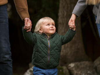 Parents walking with their cute child in the park, highlighting individuality, self-expression, autonomy, and childhood independence