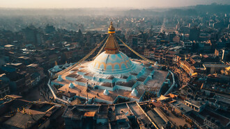An aerial view of city buildings during the daytime with the Bodhnath Stupa in Kathmandu, Nepal