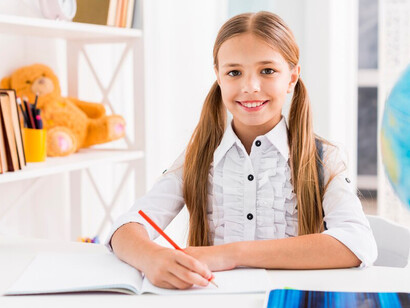 Young girl focused on writing in a notebook, representing empowerment and education for women