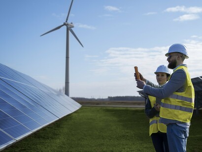 Two professionals measuring the efficiency of solar panels, a key technology in the transition to a future powered by clean, renewable energy sources