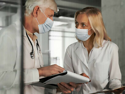 Ärzte mit medizinischen Masken unterhalten sich über die P4-Medizin und stellen personalisierte Gesundheitsfürsorge vor