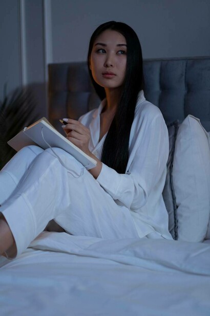 Woman journaling in her bed at night