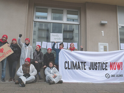 Activists display Paris Climate Agreement during protest against BUND's Coal Commission approval