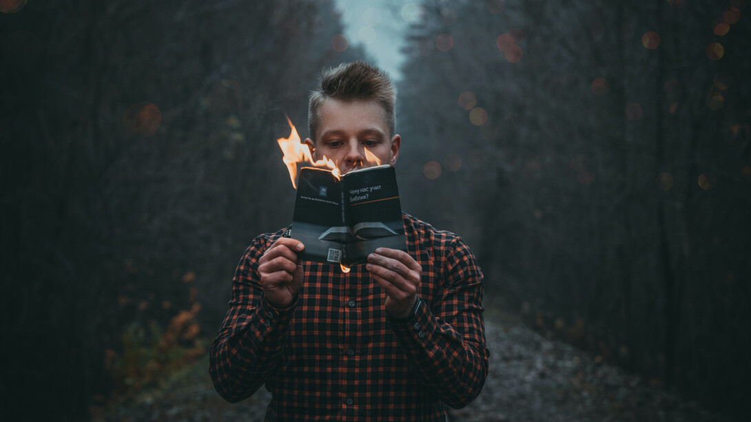 Homem lê livro em chamas