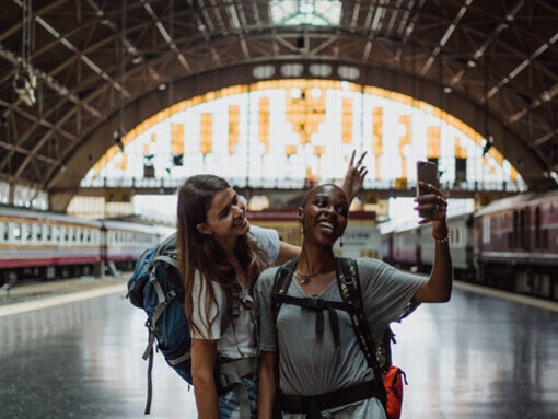 These eco-conscious travelers radiate excitement as they prepare to board their train, eager to explore destinations that leave a positive impact on Earth