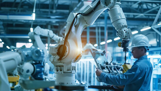 In a brightly lit, advanced manufacturing facility, a worker wearing a safety helmet closely monitors a state-of-the-art robotic arm in operation, ensuring precision and safety on the production line