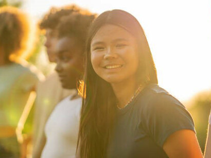 In the open air, a vibrant scene unfolds as a cluster of teenagers shares laughter and camaraderie, basking in the shared joy of their companionship