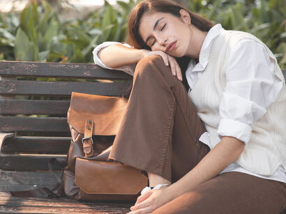 A woman sleeping on a park bench illustrates the growing laziness often seen in modern society