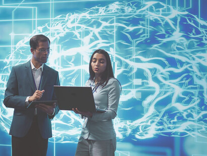 Coworkers using laptops and tablets to tackle tasks with advanced AI software